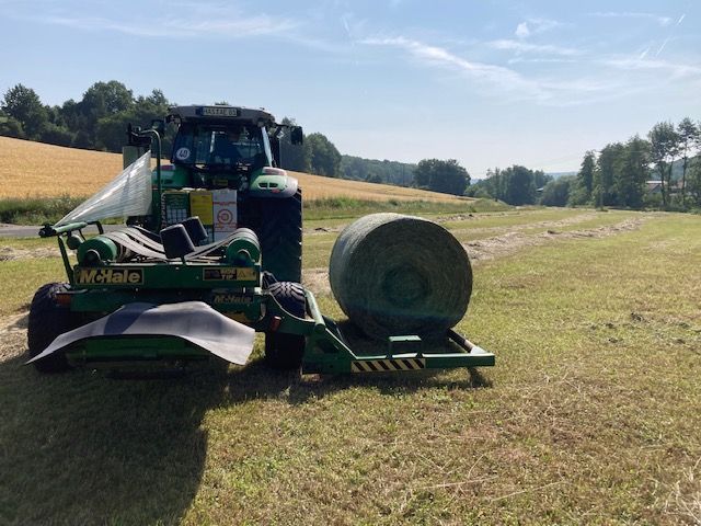 McHale Wickler beim Wickeln eines Silageballens auf der Wiese