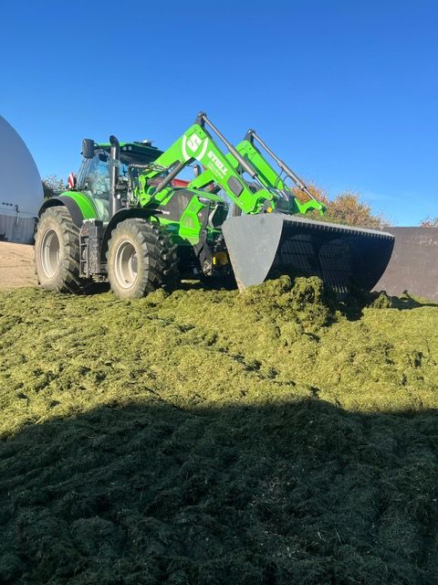 Traktor beim Verdichten der Silage auf dem Silostock